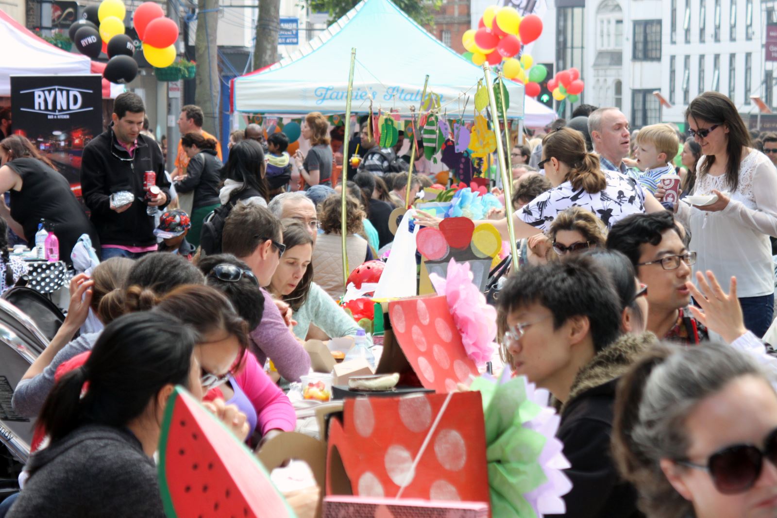 Eat Reading (Reading Food Festival): people eating at a long table with balloons and a marquee
